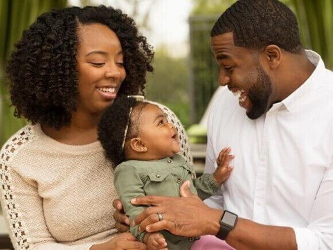 Mãe e pai sorrindo com o bebê no colo Mãe e pai sorrindo com o bebê no colo