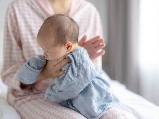 Posição clássica de como fazer para bebe arrotar: a mãe segura o bebê confortavelmente contra o ombro com um pano de boca para protegê-la contra golfadas de leite ou saliva. Posição clássica de como fazer para bebe arrotar: a mãe segura o bebê confortavelmente contra o ombro com um pano de boca para protegê-la contra golfadas de leite ou saliva.