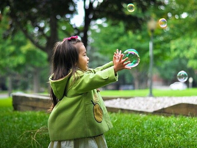 criança brincando com bola de sabão criança brincando com bola de sabão