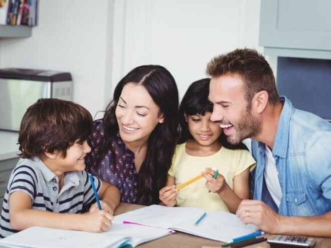 Uma família formada por pai, mãe, filho e filha sentados à mesa, sorrindo e interagindo. Uma família formada por pai, mãe, filho e filha sentados à mesa, sorrindo e interagindo.