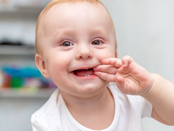 Bebê engatinhando no chão e com a mão na boca sorrindo. Bebê engatinhando no chão e com a mão na boca sorrindo.