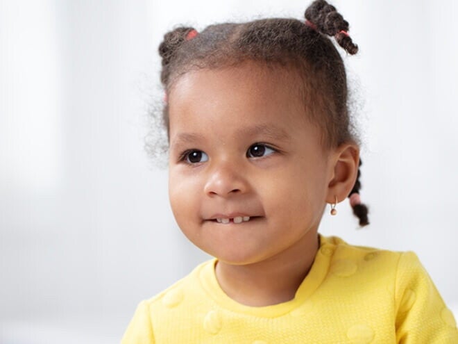 Menina vestindo blusa amarela e usando tranças no cabelo Menina vestindo blusa amarela e usando tranças no cabelo