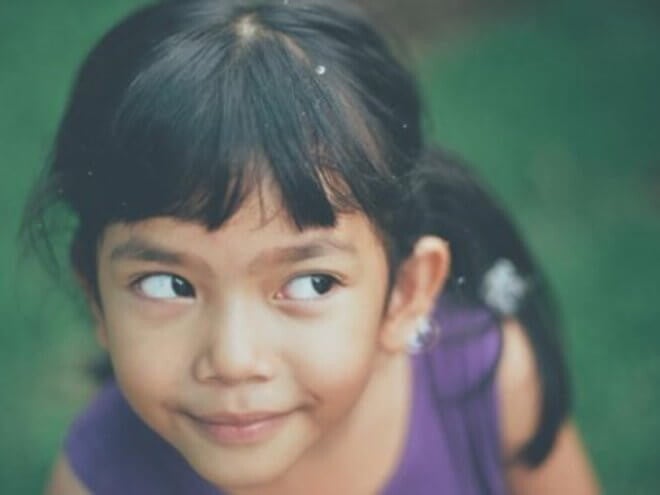 Menina de aproximadamente 5 anos em um gramado olhando para bolhas de sabão Menina de aproximadamente 5 anos em um gramado olhando para bolhas de sabão