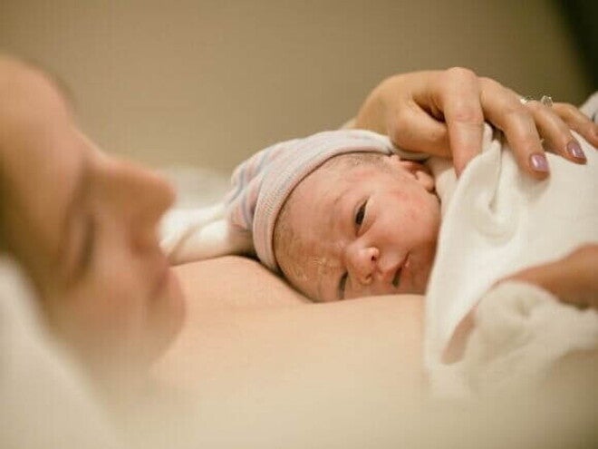 Um bebê recém-nascido deitado no colo de uma mulher. Um bebê recém-nascido deitado no colo de uma mulher.