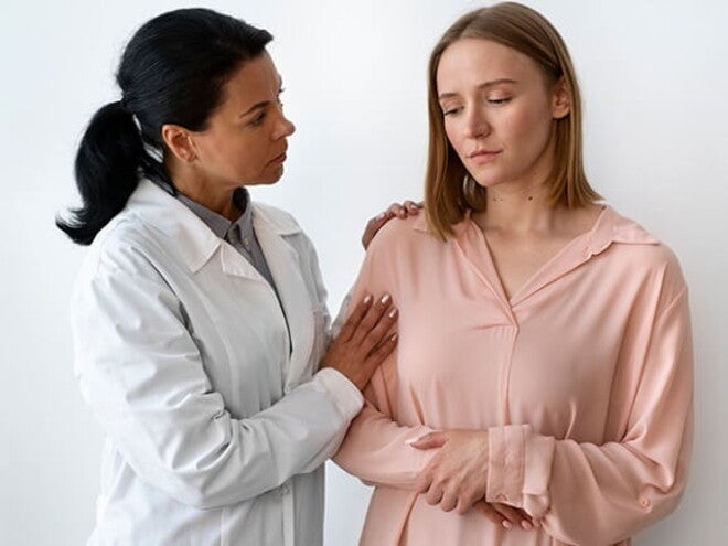 Médica examinando paciente com candidíase mamária Médica examinando paciente com candidíase mamária
