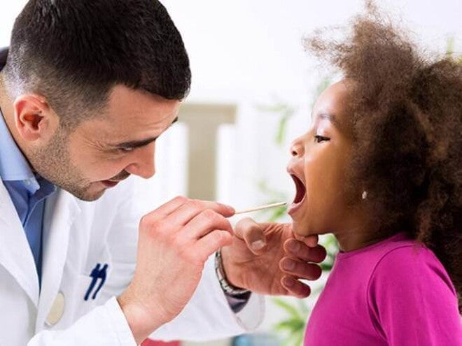 médico examinando a garganta de uma menina médico examinando a garganta de uma menina