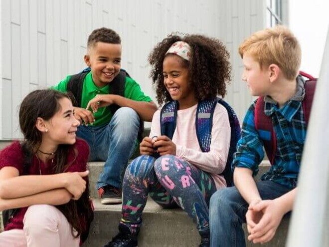 Um grupo de jovens sentados na escada e sorrindo Um grupo de jovens sentados na escada e sorrindo