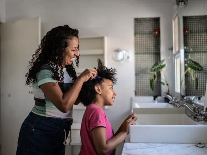 mulher faz tranças no cabelo de criança mulher faz tranças no cabelo de criança