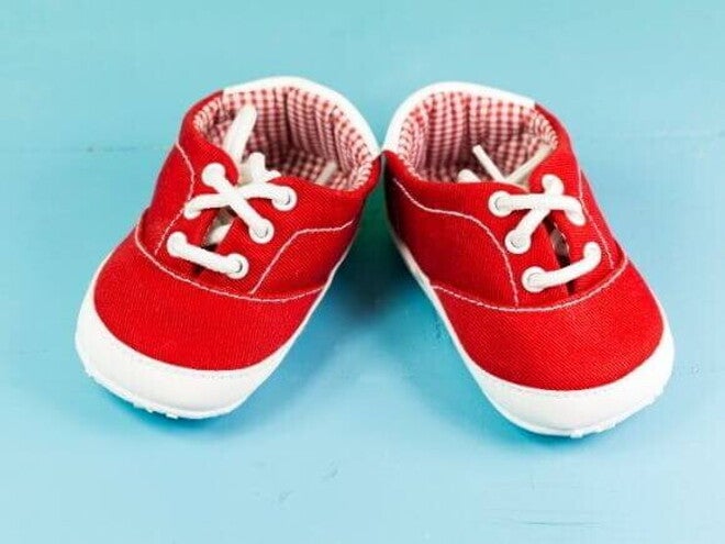 Par de sapatos de bebezinho vermelho, sobre um fundo azul. Par de sapatos de bebezinho vermelho, sobre um fundo azul.