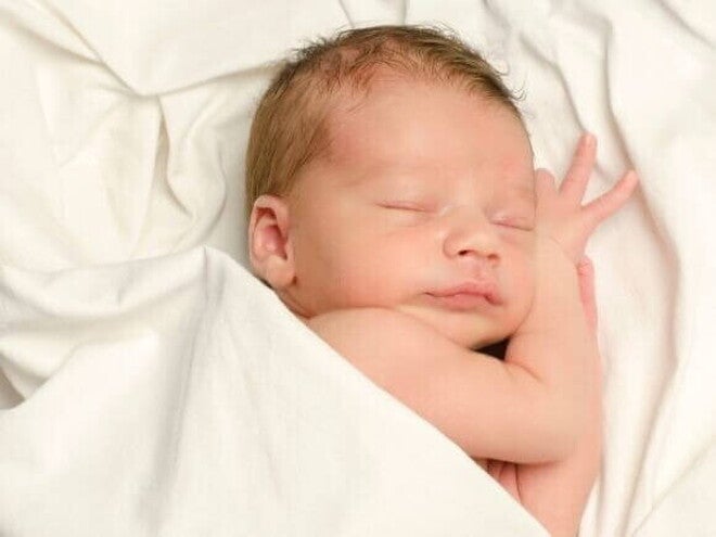Bebê dormindo, coberto por um lençol branco Bebê dormindo, coberto por um lençol branco