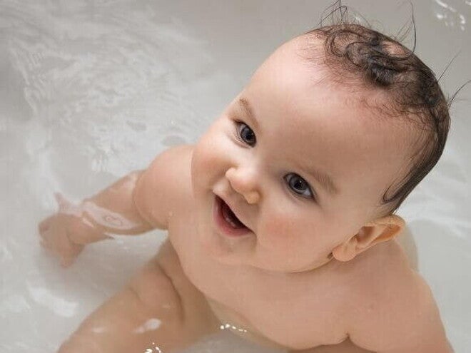 Um bebê dentro da banheira com a boca aberta Um bebê dentro da banheira com a boca aberta