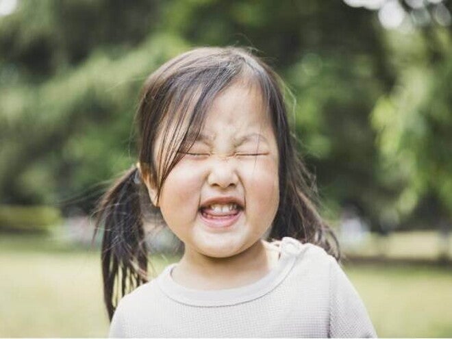 A foto destaca o rosto de uma menina fazendo caretas. A imagem remete ao tema de tique em crianças A foto destaca o rosto de uma menina fazendo caretas. A imagem remete ao tema de tique em crianças
