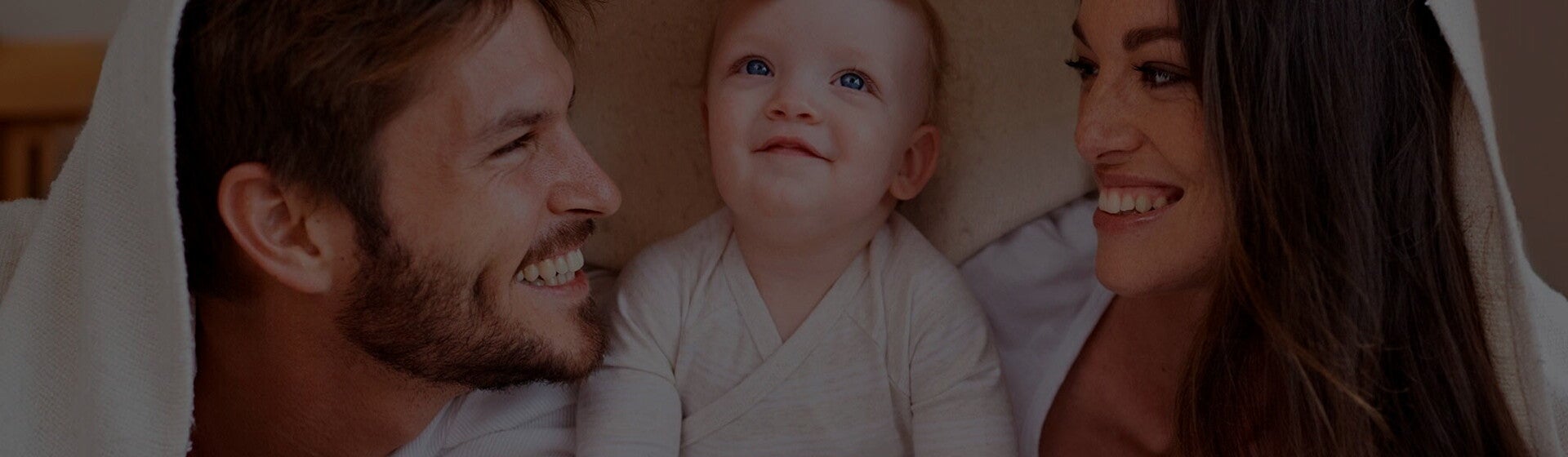 imagem de bebê entre homem e mulher, os pais, para representar tabela de crescimento do bebê