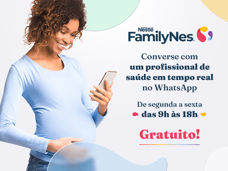 Mulher grávida olhando para o celular sorrindo