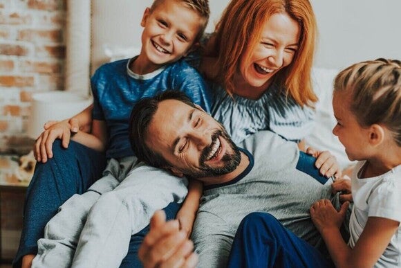 Família, pai, mãe, filho e filha rindo ao dizer trava-línguas