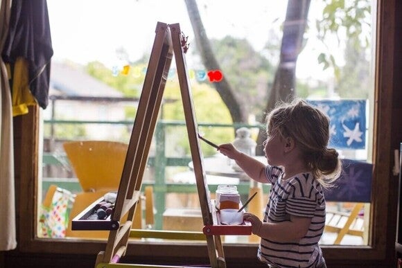 Menina pequena pintando uma tela