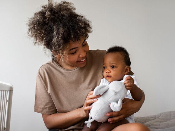 Como saber se sou neuroatípico neurodivergente? Foto de mãe segurando filho no colo