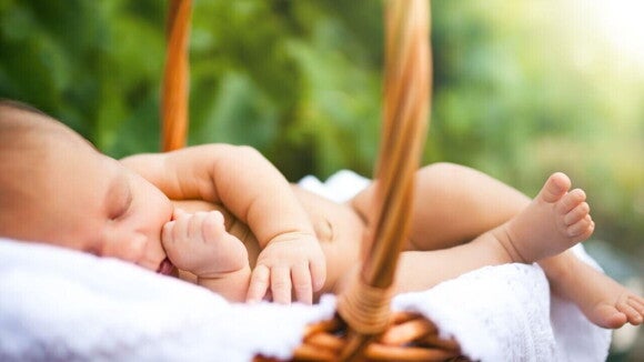 Bebê dormindo em um ambiente aberto e exposto à luz do sol Bebê dormindo em um ambiente aberto e exposto à luz do sol