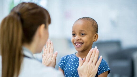 Menina sorrindo e brincando com uma enfermeira. Menina sorrindo e brincando com uma enfermeira.