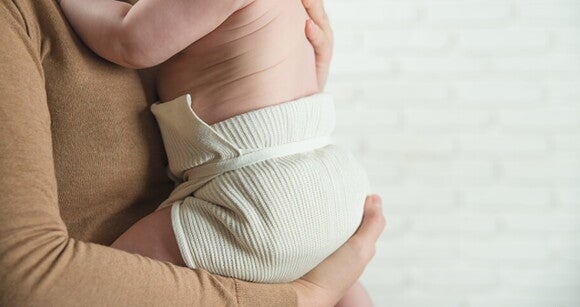 Mulher embalando delicadamente um bebê em seu colo Mulher embalando delicadamente um bebê em seu colo