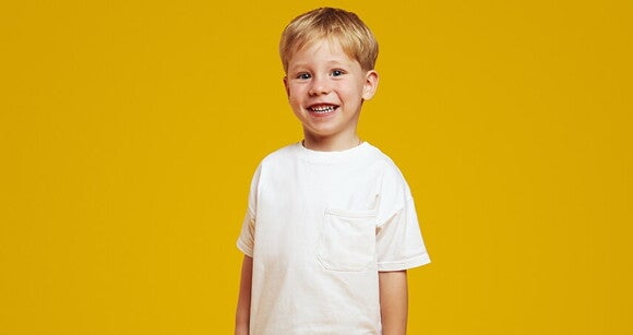 Menino loiro vestindo camiseta branca e sorrindo Menino loiro vestindo camiseta branca e sorrindo