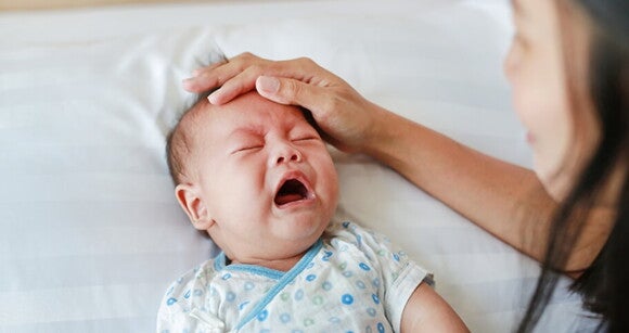 mãe acariciando bebê enquanto ele chora mãe acariciando bebê enquanto ele chora