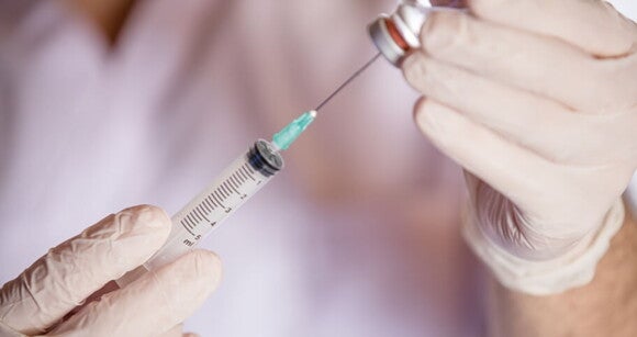 Enfermeiro usando luvas para preparar vacina de imunização contra rubéola. Enfermeiro usando luvas para preparar vacina de imunização contra rubéola.