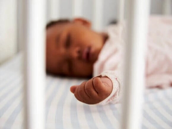 Bebê dormindo em um berço durante a rotina de sono noturna.
