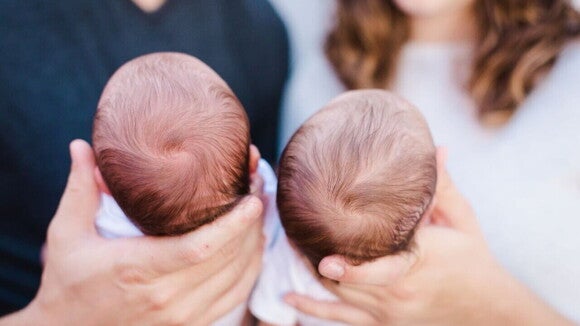 Um homem e uma mulher segurando dois bebês recém-nascidos. Um homem e uma mulher segurando dois bebês recém-nascidos.