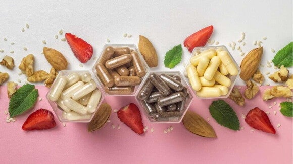 Uma composição de suplementos alimentares infantis em cápsulas, dispostas em recipientes transparentes de formato hexagonal. A imagem apresenta as cápsulas ao lado de ingredientes naturais como morangos cortados, nozes, amêndoas e folhas de hortelã, destacando a origem saudável do suplemento alimentar infantil. Uma composição de suplementos alimentares infantis em cápsulas, dispostas em recipientes transparentes de formato hexagonal. A imagem apresenta as cápsulas ao lado de ingredientes naturais como morangos cortados, nozes, amêndoas e folhas de hortelã, destacando a origem saudável do suplemento alimentar infantil.