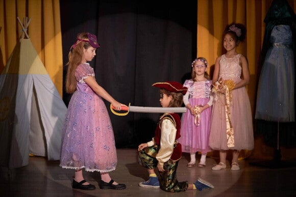 Grupo de crianças em cima de um palco, atuando em uma peça de teatro infantil. Grupo de crianças em cima de um palco, atuando em uma peça de teatro infantil.